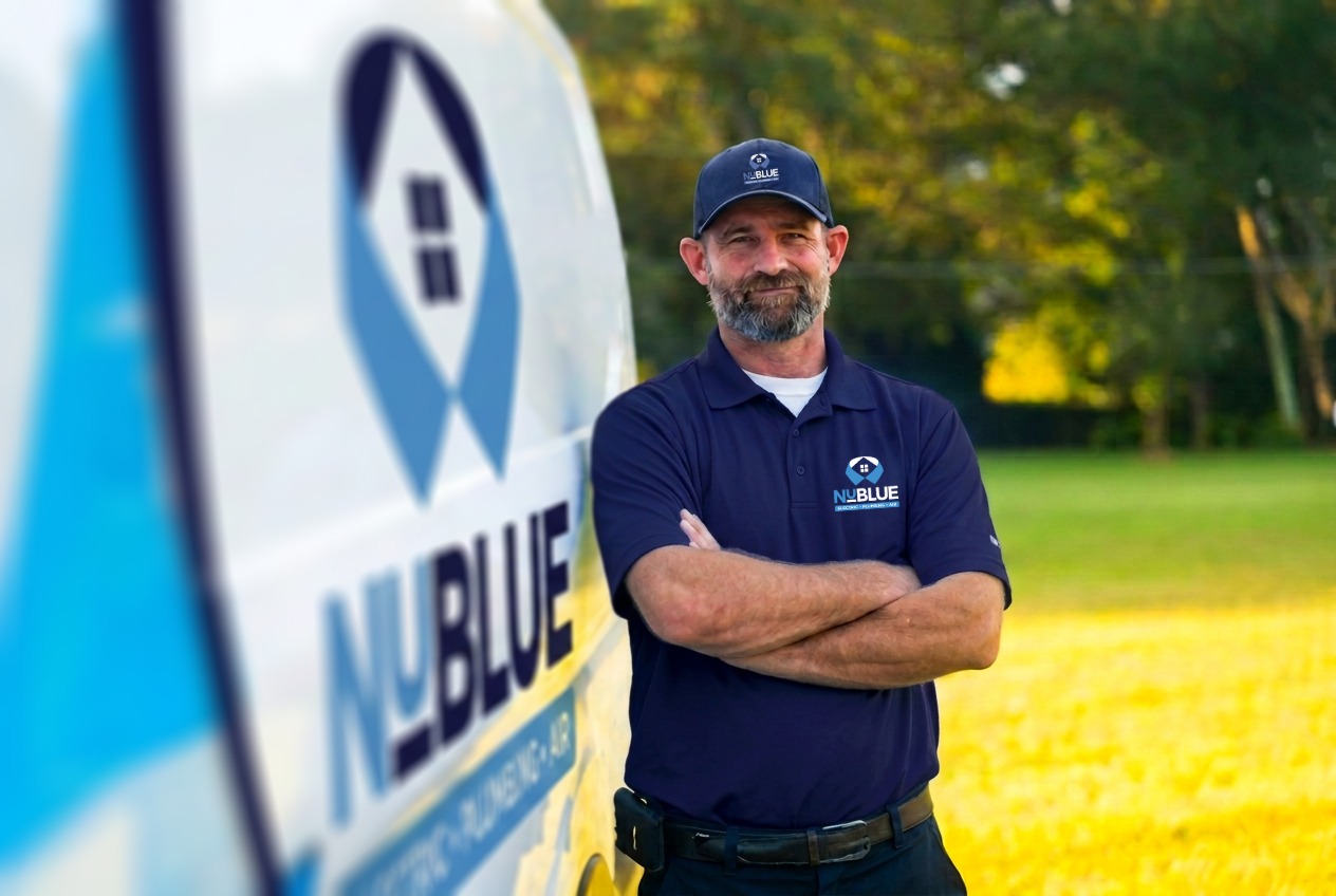 NuBlue technician standing next to a service van, with arms crossed.